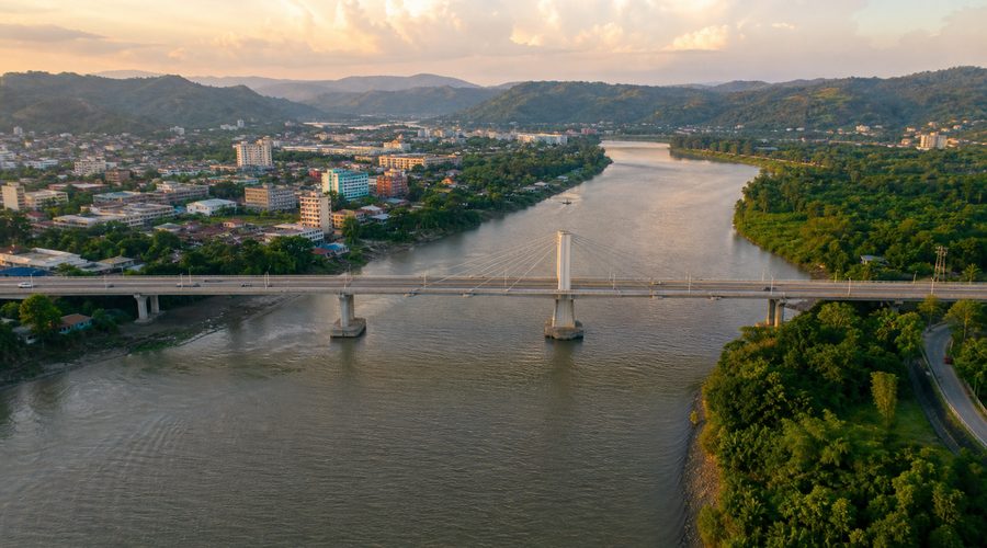 A bridge crossing the Cagayan de Oro River, with the city and green hills beyond