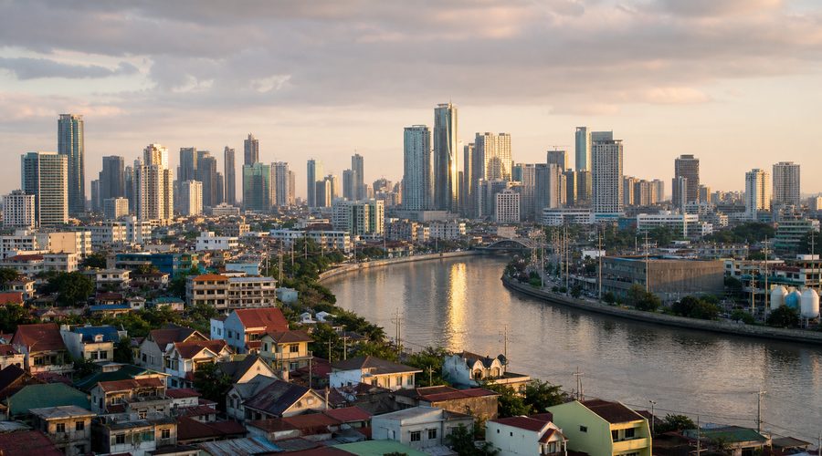The Pasig River curving past high-rise towers, with low-rise homes in the foreground