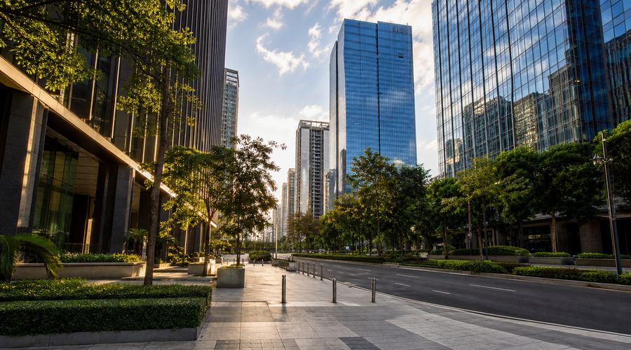 A wide, tree-lined boulevard between glass office towers in Bonifacio Global City